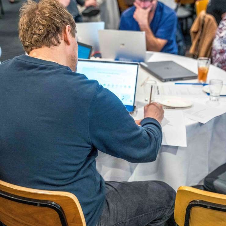 Attendees working at a table with laptops