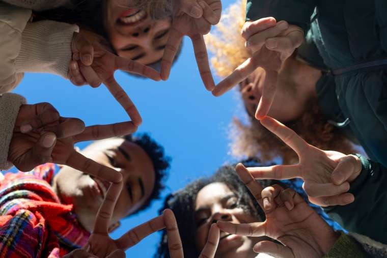 Group of diverse friends making star shape with fingers